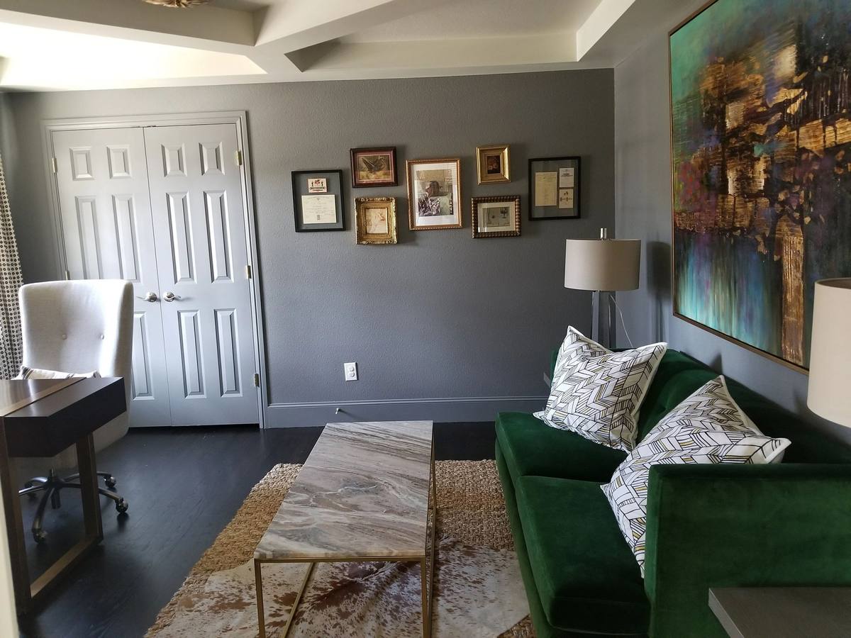 Living area with dark green sofa and gray walls