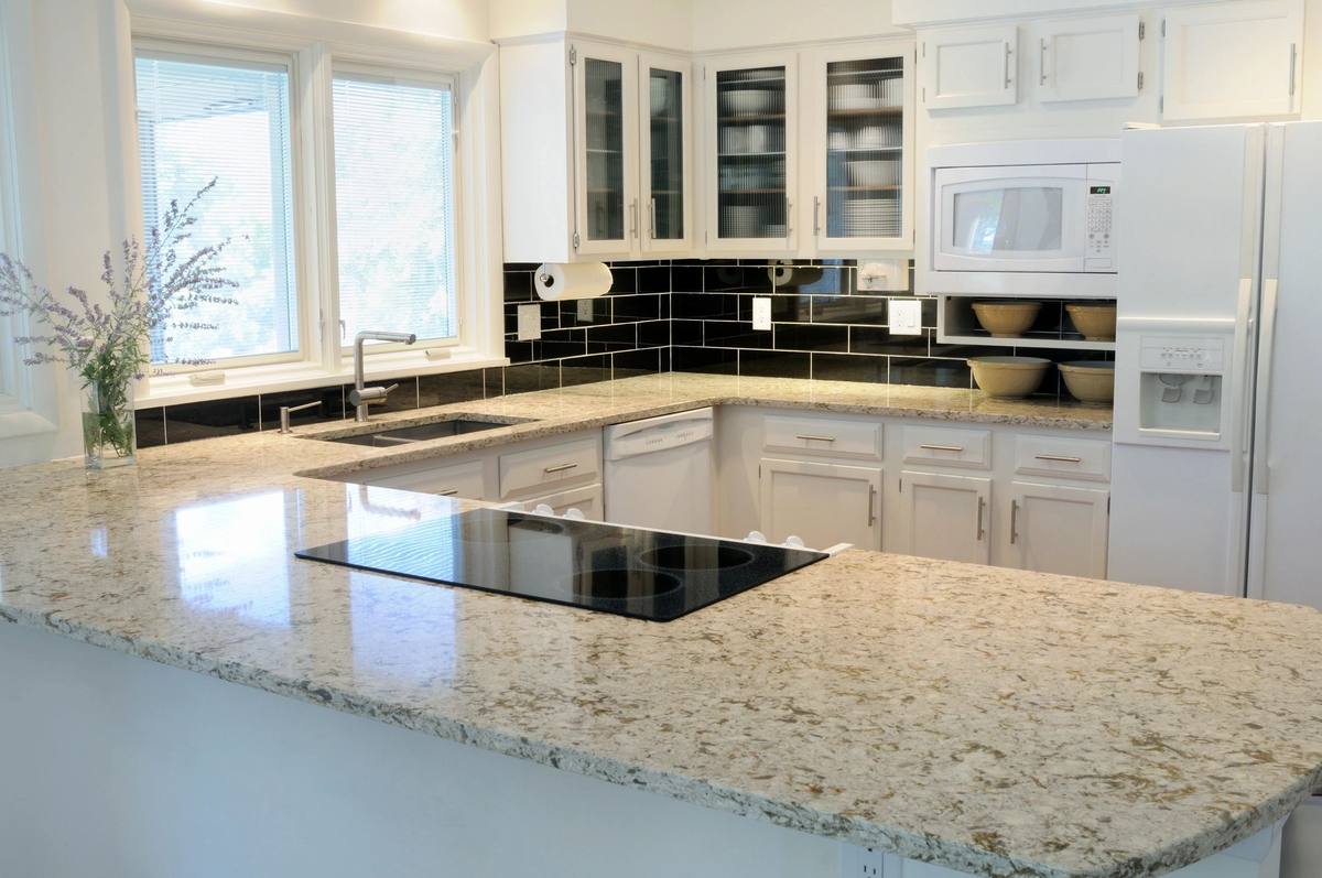 White kitchen with granite island and dark tile backsplash