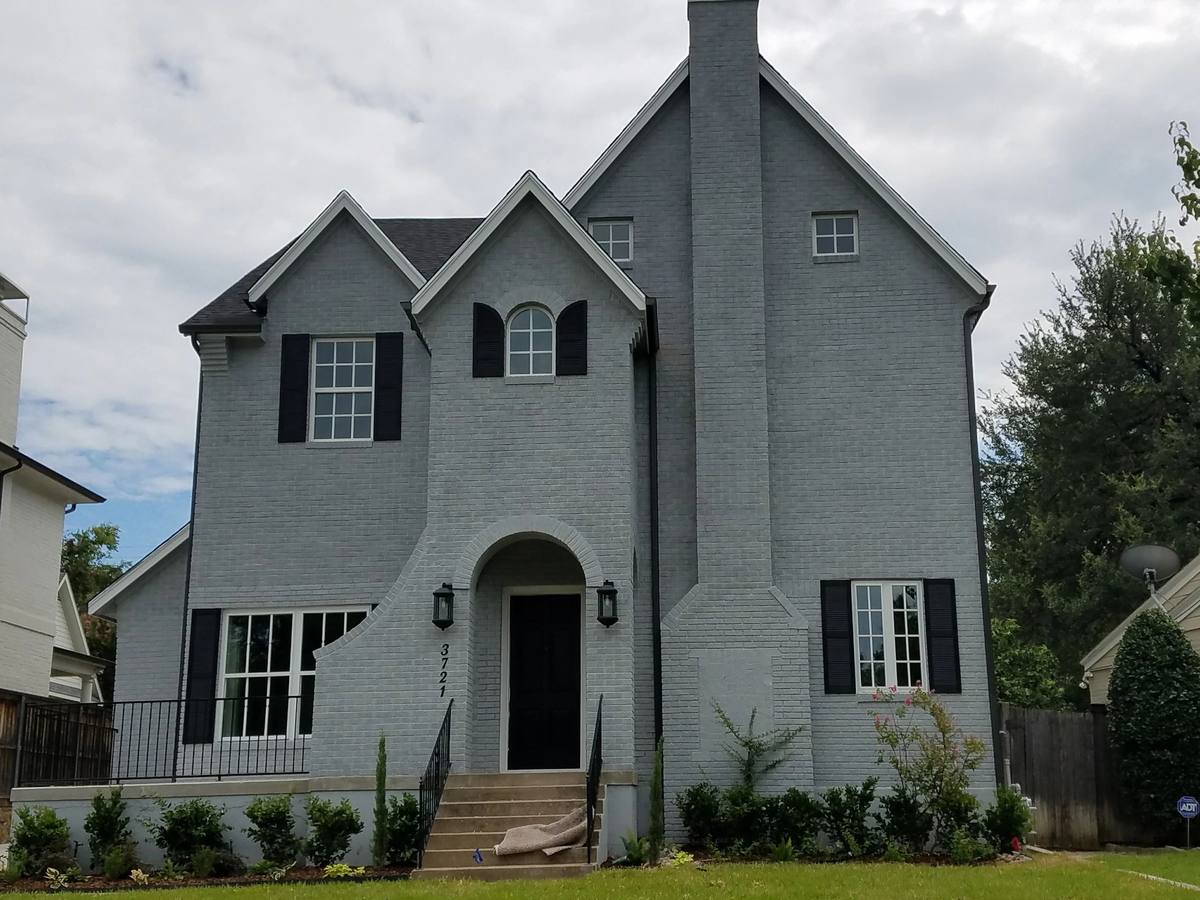 Gray two-story home exterior with dark window trim