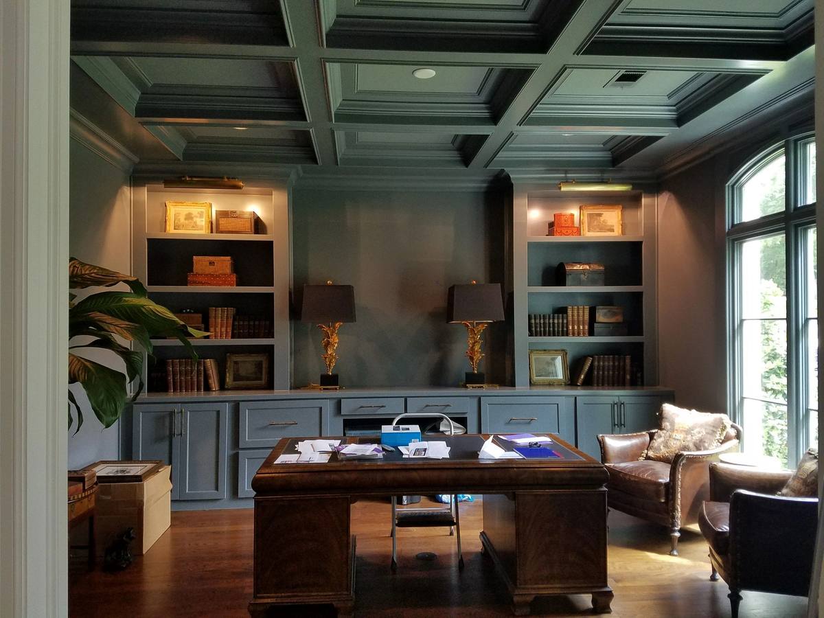 Room with dark coffered ceiling and built-in cabinetry